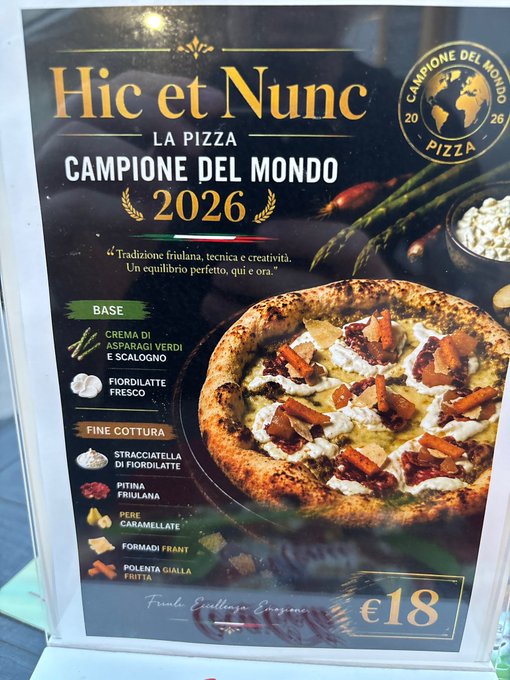 The image shows a poster for a pizza, with the text "Hic et Nunc la Pizza". This suggests that it's an Italian pizza. The poster also displays some information about the pizza, including its name and price. It appears to be located in an Italian location, as indicated by the presence of foreign words on the postcard. The focus of this image is on the pizza itself, inviting viewers to consider trying this delicious dish at the restaurant.