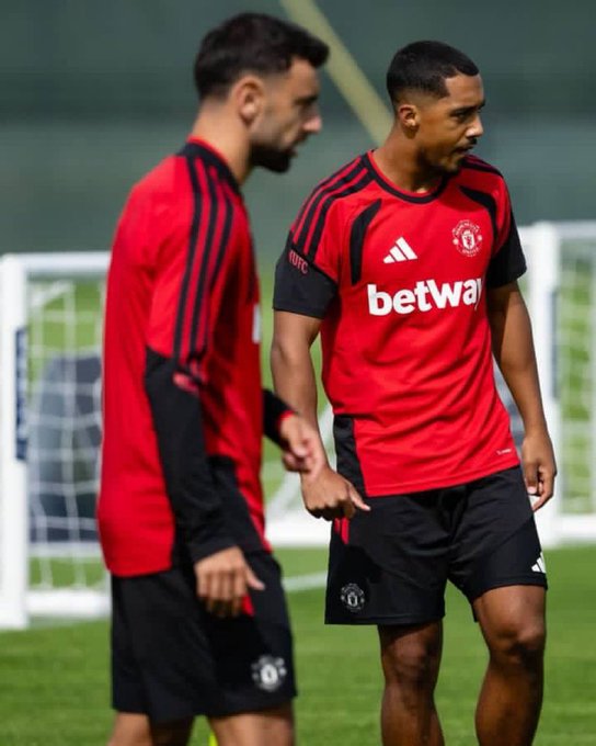 Two soccer players in red and black Manchester United training gear, with "betway" sponsorship visible on the jersey, stand on a practice pitch near a goal.

The image plays on the caption "My lambos" by humorously highlighting the players' fit physiques and confident stances, jokingly referring to their muscular legs as their prized "lambo" muscles.
