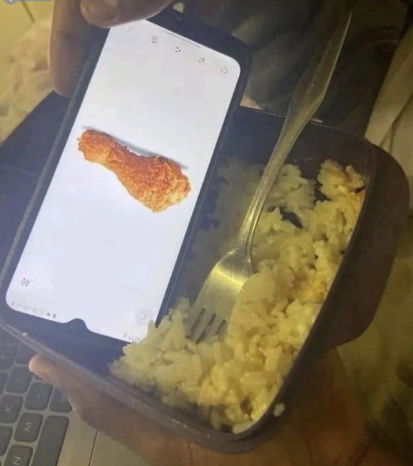 The image features a person holding a cell phone with an image of fried chicken on its screen, which appears to be a meme or a funny picture. The person's hand is also holding a fork filled with rice. The caption below the image reads "Crypto bros in this market:".