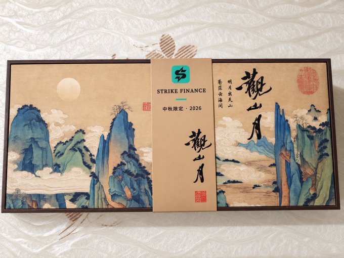 Two decorative boxes featuring classical Chinese landscape paintings in blue and green tones, with text including 'STRIKE FINANCE', '中秋限定 · 2026', and '觀山月' (Guanshan Moon).