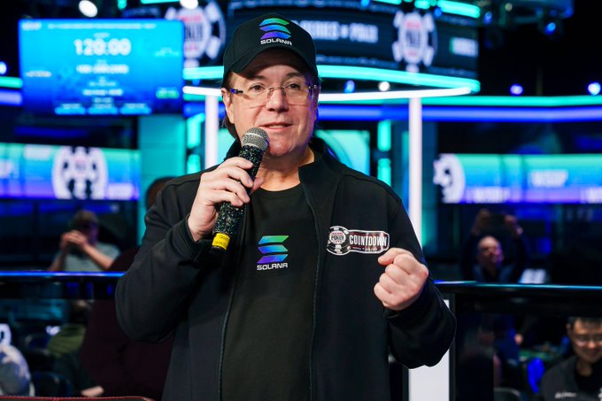 Jamie Gold, the 2006 WSOP Main Event champion, speaks into a microphone while wearing a black cap and shirt featuring the Solana logo, alongside a "WSOP COUNTDOWN" badge, highlighting the tournament's new partnership with the cryptocurrency platform.
