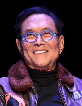Robert Kiyosaki, wearing distinctive blue glasses and a brown fur-collared jacket, smiles at the camera, appearing as the figure behind the bold prediction that Ethereum ($ETH) could surge to $95,000 by mid-2027.