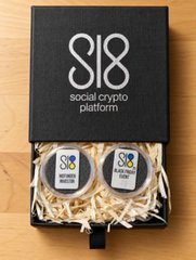 A black gift-style box branded with "SI8 social crypto platform" is open to reveal a wooden Ukrainian trident emblem and white shredded paper, symbolizing Sl8's Ukraine Independence staking round that layers multiple benefits beyond just an APY.