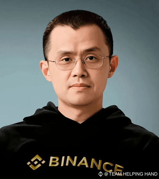 A portrait of CZ (Changpeng Zhao), the founder of Binance, wearing a black Binance-branded hoodie and glasses, with '@TEAM_HELPING_HAND' watermark.