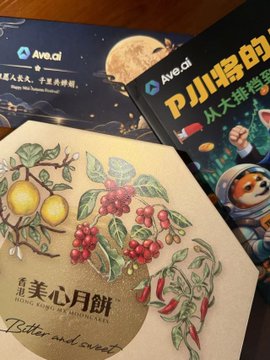 Two Ave.ai promotional items featuring a moon design and a Pika character in a spacesuit, placed next to a booklet titled '美心月饼' (Meixin Mooncakes) decorated with illustrations of lemons, coffee berries, and chili peppers.