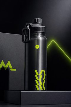 A black Monster energy water bottle with the iconic green claw logo and 'H2O' label displayed on a black surface with neon green lighting accents.