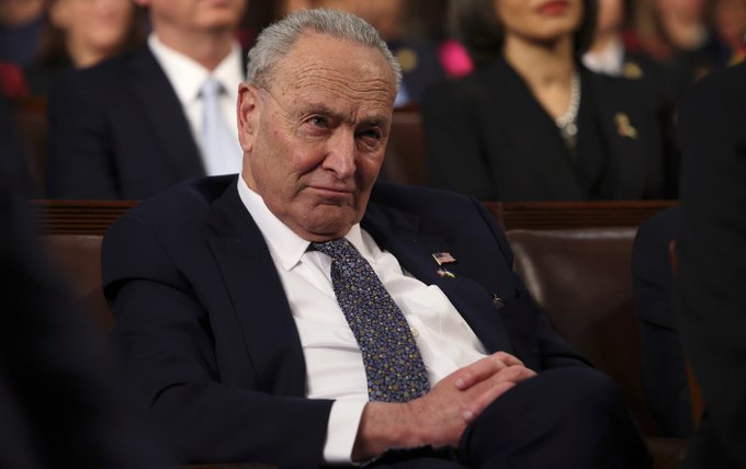 An older man in a dark suit and patterned tie sits with a contemplative expression, with other attendees visible in the background of what appears to be a formal political setting. The image likely relates to the post as it shows a senior political figure who may be connected to the Senate's deliberations on the Crypto Clarity Act.