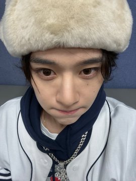 A young man wearing a cream-colored fur hat and a white jacket with a navy scarf looks down with a disappointed, pouty expression. His sulky face perfectly captures the "expensive" frustration mentioned in the post about using Terra.