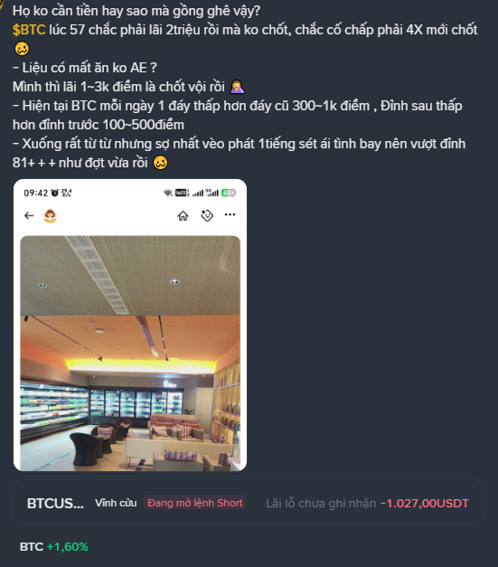 A screenshot of a Vietnamese crypto trading chat where a user with a short BTC position displays a -1,027.00 USDT unrealized loss (with BTC up +1.60%) in an empty café, expressing frustration that BTC dropped only 300-1K points from its previous 100-500K range instead of crashing 4X from 57K as they anticipated, noting their potential profit could have reached 2 million had they not waited. The image illustrates the post's point about the psychological pressure of holding a losing short position while BTC recovered from 57K, highlighting the patience and stress required to maintain such a trade.