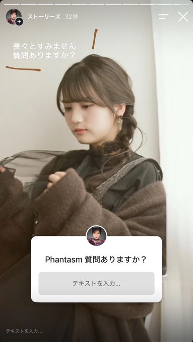 An Instagram Story screenshot shows a young woman with long brown hair and bangs, wearing a dark green top under a brown knit sweater, looking down while adjusting her hair. Japanese text on the image reads "長々とすみません 質問ありますか？" (Sorry for the long message, do you have any questions?). At the bottom, a story reply box appears from "Phantasm" asking "質問ありますか？" (Do you have any questions?) with a text input field, reflecting the recruitment call for Oni product introductions and Q&A engagement mentioned in the post.