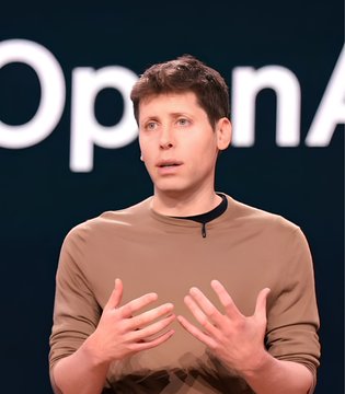 Sam Altman, CEO of OpenAI, speaks while gesturing with both hands in front of a stage backdrop displaying the OpenAI logo.