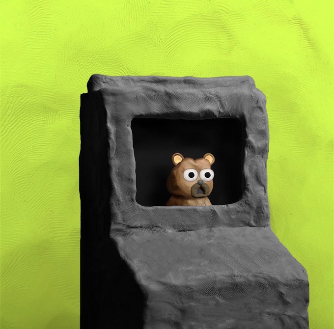 A small clay bear figure with googly eyes sits inside a dark, rocky cave opening against a bright lime green background.