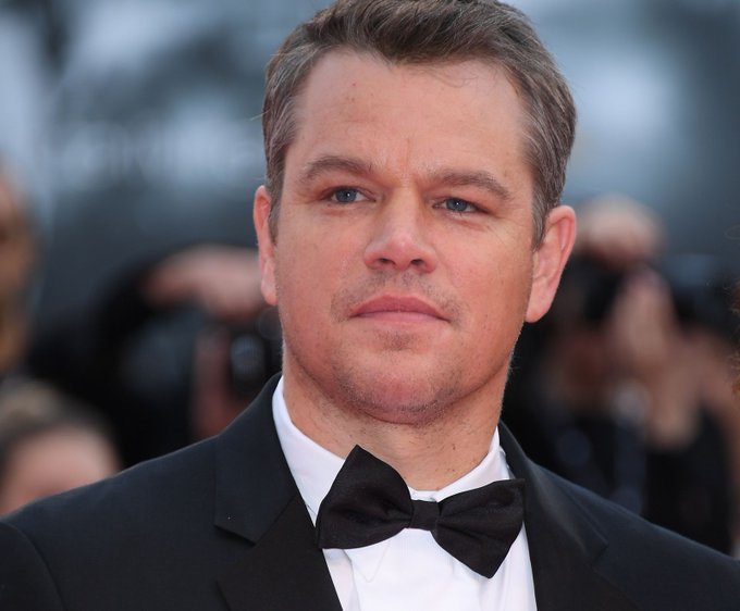 The image features a man dressed in a tuxedo with a black bow tie, standing against a blurred background of people at an event. The caption reads "BREAKING NEWS: Hollywood superstar Matt Damon will attend the Ripple Swell Conference in New York", indicating that the man is attending a high-profile conference or event related to cryptocurrency and blockchain technology.