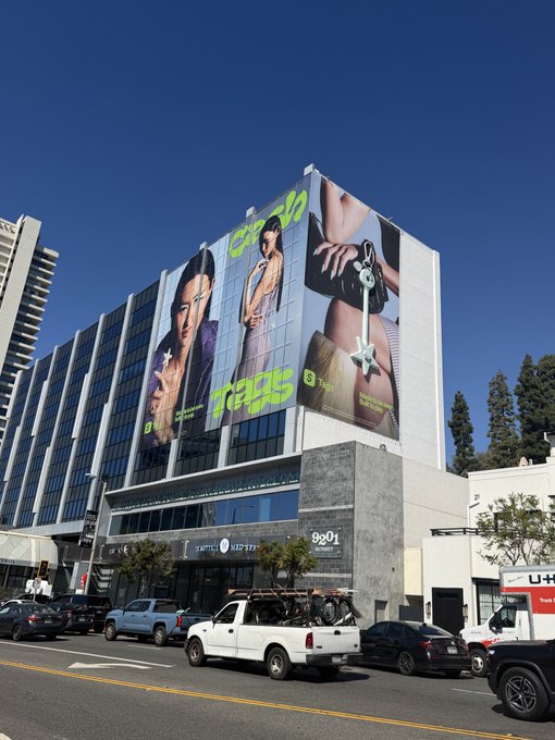 Street view of a building featuring a large billboard advertisement for 'Daisy Jones & The Six' on the Amazon MGM Studios building.
