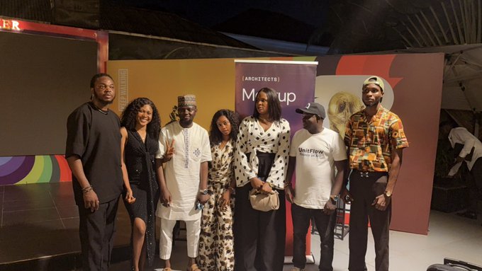A group of seven stylishly dressed individuals pose together at an Arc [ARCHETECTS] Meetup event, with one attendee wearing a "OnitFlow" branded t-shirt. The backdrop displays the event's branding, reflecting the celebratory post about "Arc Mainnet 9.16.26 built different."