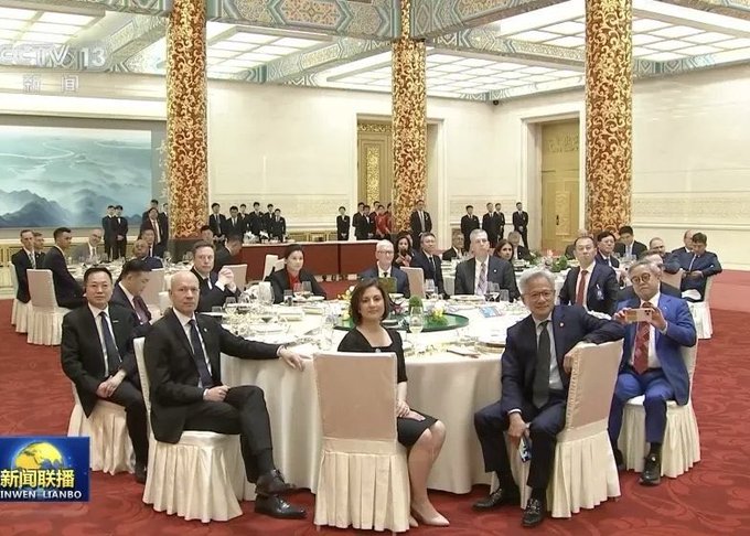 A CGTN broadcast (CCTV-13) shows a formal banquet in a grand hall, with dignitaries including Tim Cook and Jensen Huang seated at a round table during a Chinese state dinner.