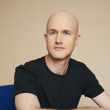 The image shows a bald man with a neutral expression, wearing a black t-shirt, seated against a beige background. The post appears to attribute the quoted statement about the CLARITY Act and bank competition to this individual, identified as Coinbase CEO Brian Armstrong.