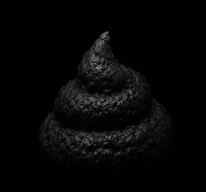 A coiled pile of poop emoji is rendered in dark, textured stone against a completely black background.