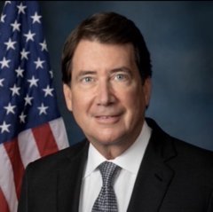 An official portrait of William R. Hagerty IV, an American politician and former U.S. Ambassador to Japan, posing in front of an American flag.