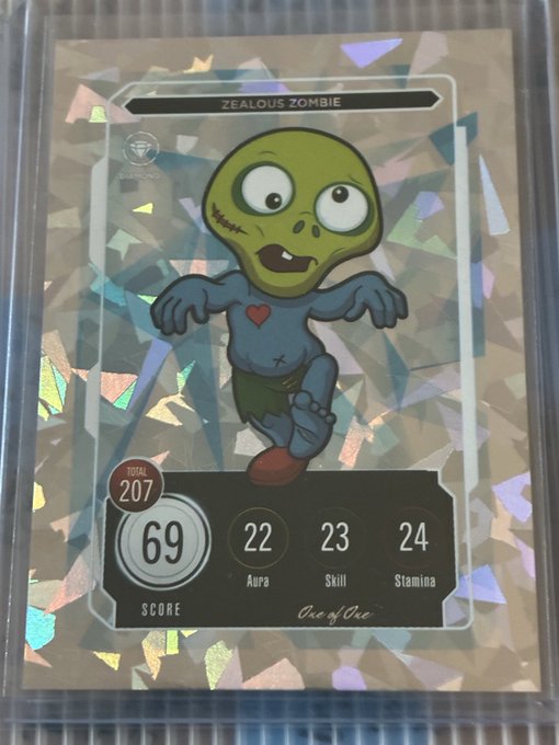 A holographic trading card features a cartoon zombie character with the text "ZEALOUS ZOMBIE" at the top and "One of One" at the bottom, displaying a score of 69 and stats for Aura (22), Skill (23), and Stamina (24).