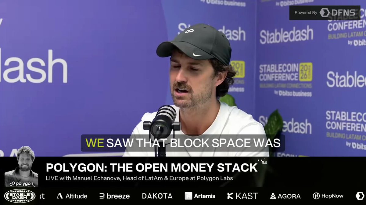 The image shows a man wearing a baseball cap, speaking into a microphone at a conference or event. The background features a blue banner with white text that reads "Polygon: The Open Money Stack", indicating an association between Polygon and the blockchain technology. The caption below the image provides further context about the content of the post on social media platforms.