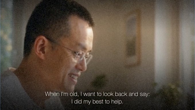 A smiling middle-aged man with glasses in profile, with subtitles reading 'When I'm old, I want to look back and say: I did my best to help.'