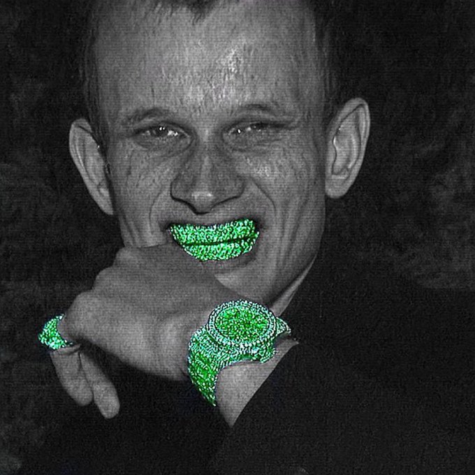 A black-and-white photo of a smiling man with his hand on his chin, featuring green "diamond" emoji-style overlays on his teeth, watch, and ring—visually emphasizing the luxury jewelry often referenced in posts about Ethereum's price reaching $2,200.