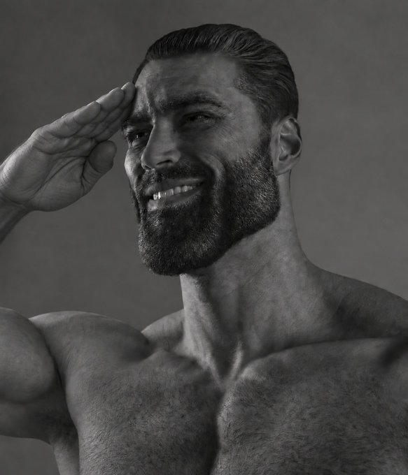 A black-and-white photograph of a muscular, bearded shirtless man smiling and saluting with his hand to his forehead.