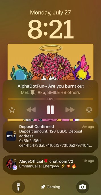 An iPhone lock screen at 8:21 on Monday, July 27, showing a live "AlphaDotFun" space with 11+ participants (MEL, Aku, SMILE +8 others), a BYBIT deposit confirmation for 120 USDC, and a notification from "AlegeOfficial" chatroom V2—illustrating the active engagement, crypto transactions, and community support referenced in the Day 12 recap.