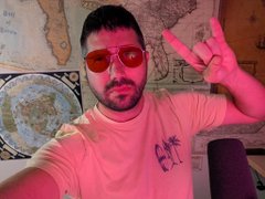 A young man with a beard wears red-tinted sunglasses and a pink shirt, flashing a peace sign in front of a world map, celebrating the rapid 70% surge of his meme coin $SPROUT on Robinhood App.