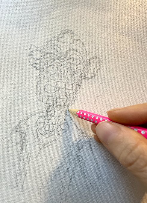 A hand holds a pink polka-dot pencil sketching a detailed portrait of a skeleton figure wearing a jacket on canvas.