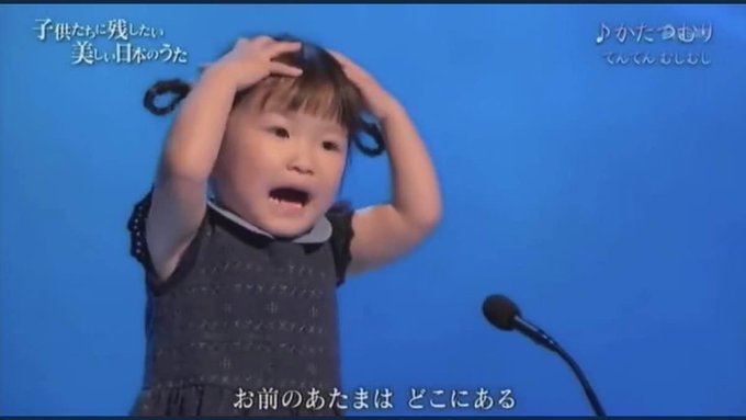 In this image, a surprised child sings "Kata-tsumuri" with on-screen lyrics "子供たちに残したい 美しい日本のうた" and "お前のあたまはどこにある", implying a shift in the company's focus from meme coins like $NYAN, $WWB, and $AGF.