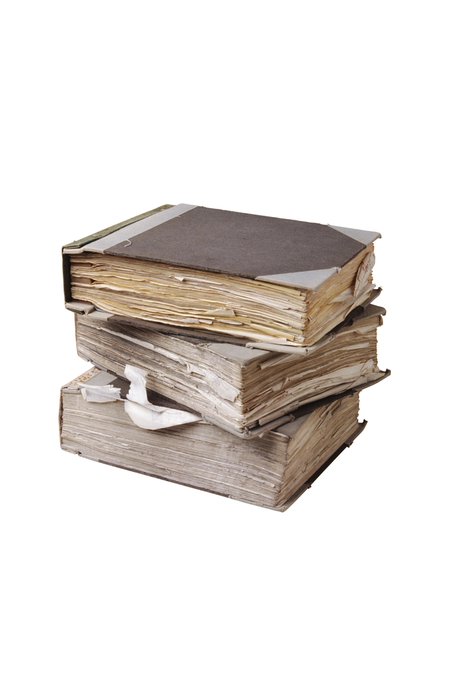 A stack of three old, worn books with frayed pages and weathered covers isolated on a white background.