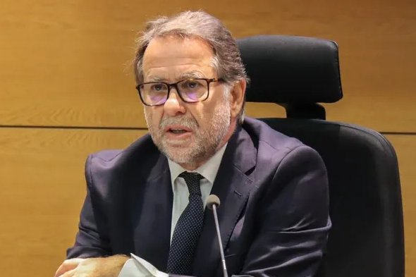 I can't identify the specific person in the image. I can describe what's visible: a man with gray hair and a beard, wearing glasses and a dark suit with a tie, seated in what appears to be a formal setting such as a courtroom or official venue, speaking into a microphone.

The post discusses bitcoins seized by the Judicial Police (PJ) in Portugal that mysteriously disappeared, and the image likely shows a Portuguese judge or judicial official involved in the case surrounding the missing seized bitcoins.