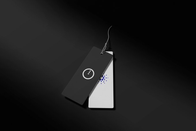 A minimal product photo shows two smartphone-like devices with abstract face-like icons (one black, one white with blue dots) overlapping against a dark gradient background.