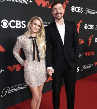 MrBeast (Jimmy Donaldson) and his girlfriend Thea Booysen posing together on a red carpet at a Paramount+ and MTV event, with CBS and MTV logos visible on the backdrop.
