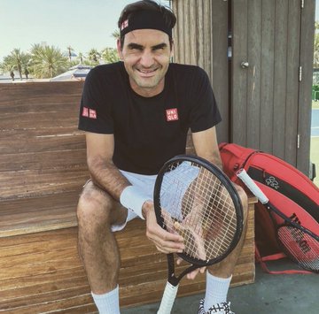 Roger Federer, the legendary tennis player wearing a Uniqlo shirt, sits smiling while holding a tennis racket beside a red Wilson tennis bag. The image ties into the post's claim of a "$2.3M tennis wallet" cashing out ~$205K across ATP tournaments, leveraging Federer's iconic tennis brand to lend credibility to the trading "tennis wallet" hype.