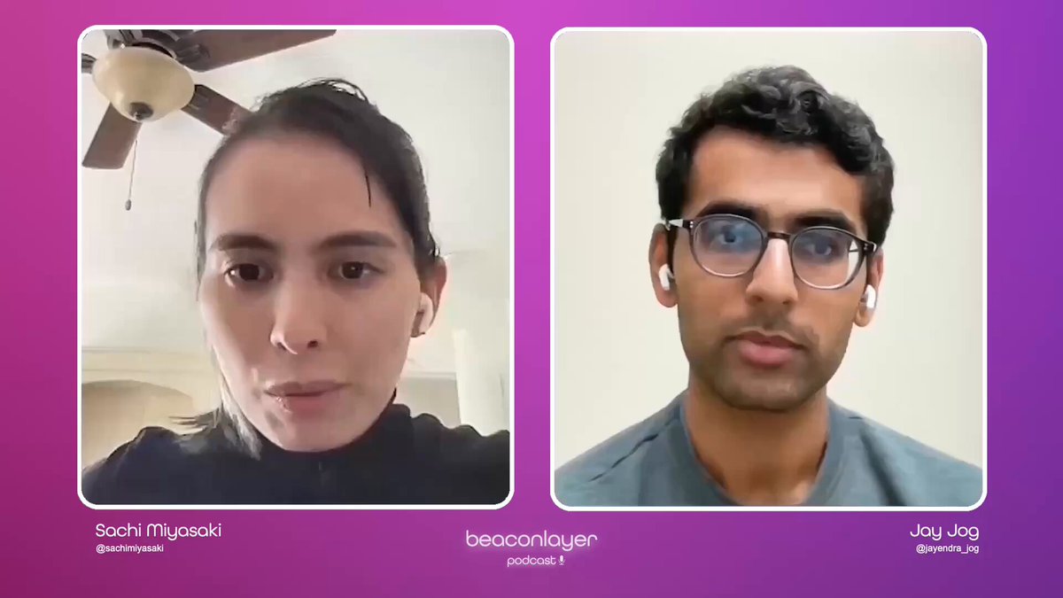 The image shows two people sitting next to each other for a video call. They are both wearing glasses and appear to be engaged in conversation with one another. The background of the image features a purple wall, which contrasts with the white ceiling fan above them. There is also text visible on the image that reads "Focus on what is in the image and how it relates to the post - @sachimiyasaki sits down with @jayendra_jog , Co-Founder of @SeiNetwork".