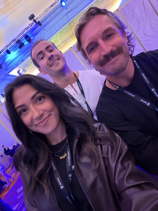 Three people pose for a selfie at the Token2049 conference, wearing lanyards that read "TOKEN2049" and "bit digital." The image captures a casual moment at the event referenced in the post, which promotes Midnight's presence at Token2049 and an "Enter the Night" side event.