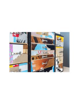 The image shows a stack of decorated storage drawers with labels including "ARCHIE" and various images like flip-flops and landscapes, serving as a backdrop for the text commenting on the time disparity in creating digital NFT art versus traditional artwork.