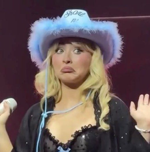 iced tea with a blue straw, a white cup, and a black hat with a feathery top are present on the stage.
