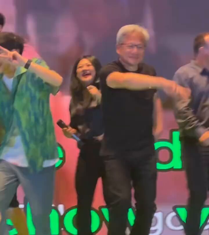 The image features a group of people dancing together, with one man wearing glasses and holding a microphone while another woman stands next to him. The background includes a sign that says "People who sold bitcoin and crypto at the top and rotated everything into AI last year". This suggests that the event might be related to cryptocurrency or digital assets, possibly an exhibition or a performance showcasing the latest trends in the world of cryptocurrencies.

The people are dressed casually, with some wearing ties as part of their attire. The man holding the microphone appears to be singing or speaking, while the woman standing next to him seems to be enjoying the moment and engaging with her fellow dancers.