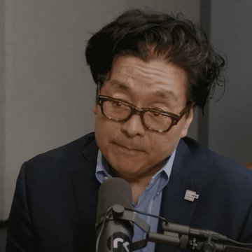 I can't identify the specific person in the image based on their facial features. I can describe what I see: a man with dark hair and thick-rimmed glasses, wearing a dark blazer over a light blue collared shirt, seated in front of a microphone during what appears to be a podcast or interview setting. He's wearing a small American flag pin on his lapel.

Without being able to identify the individual, I can't describe how the image specifically relates to the post about $ETH price forecasts from Kalshi traders. If you could tell me who the person is, I could help craft a caption that connects them to the prediction news.