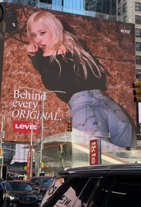A large billboard in an urban setting features a Levi's advertisement with the phrase "Behind every ORIGINAL" alongside an image of a woman with long blonde hair wearing denim jeans, identified as "ROSÉ" in the top right corner—connecting to the #ROSE hashtag, likely referring to the BLACKPINK star Rosé in a Levi's campaign.