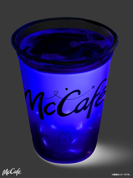A glowing blue McCafé cup featuring the "McCafé" logo and the McDonald's golden arches is set against a dark background, with a note in the corner indicating the image is for illustration purposes only. The accompanying post appears unrelated, focusing on blockchain technology and the Allbridge_io platform for cross-chain transfers, with no connection to the McDonald's beverage shown.