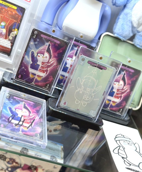 A collector displays their complete set of Lil Pudgys trading cards in protective sleeves, featuring colorful cosmic-themed designs and a special sketch variant marked "6/10," celebrating their achievement of being the first to collect all variants of a licensed Pudgy Penguins card.