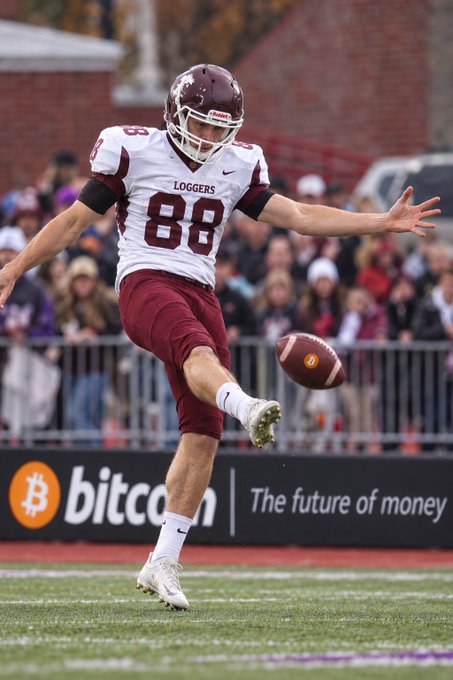 A "Loggers" football player wearing jersey number 88 kicks a football during a game, with a "Bitcoin - The future of money" advertisement visible on the sideline banner. The image captures the punter's kicking motion, playing on the post's celebration of "day 88" and punting as the featured moment.