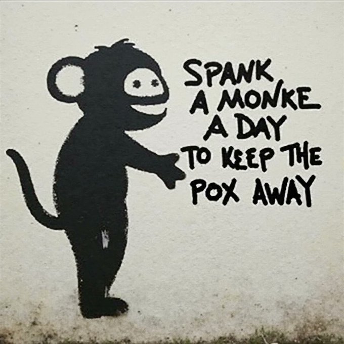 A piece of black stencil graffiti showing a smiling monkey on a wall with the humorous text 'SPANK A MONKE A DAY TO KEEP THE POX AWAY'.