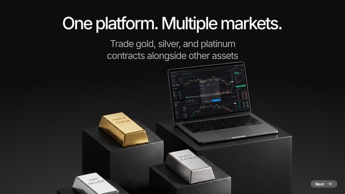 Advertisement reading 'One platform. Multiple markets. Trade gold, silver, and platinum contracts alongside other assets' with gold bars and a laptop showing trading charts.