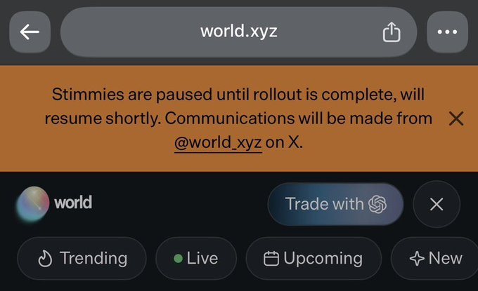 A mobile browser screenshot showing world.xyz with an orange notification banner stating 'Stimmies are paused until rollout is complete, will resume shortly. Communications will be made from @world_xyz on X.'